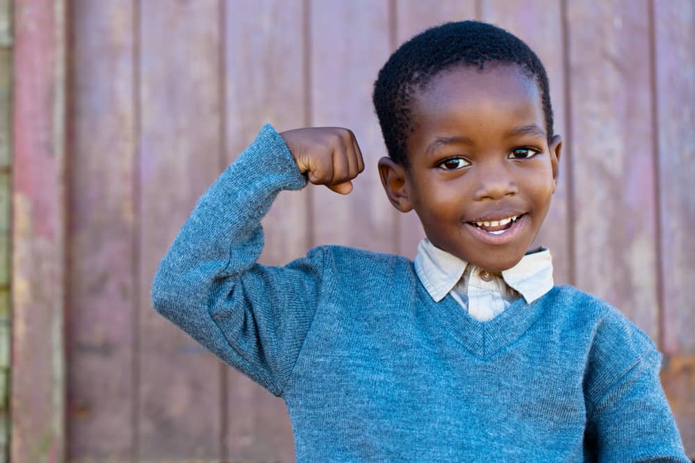 Child smiling and flexing biceps